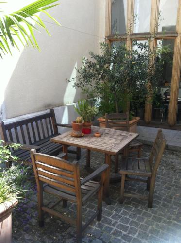 une table en bois, deux chaises et une table avec des plantes dans l'établissement Chambre d'Hôtes Annelets, à Paris