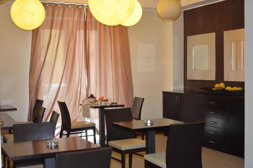 a dining room with tables and chairs and pink curtains at Cassisi Hotel in Milazzo