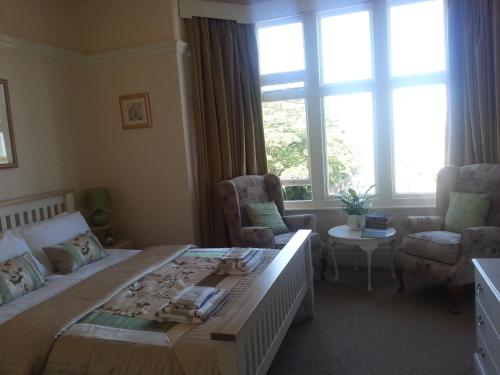 a bedroom with a large bed and a living room at Sunset Guest House in Hunstanton