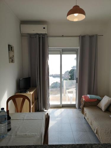 a living room with a bed and a sliding glass door at Casa João Bravo in Albufeira