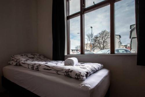 Bett in einem Zimmer mit Fenster in der Unterkunft Stay Iceland apartments - B 22a in Reykjavík