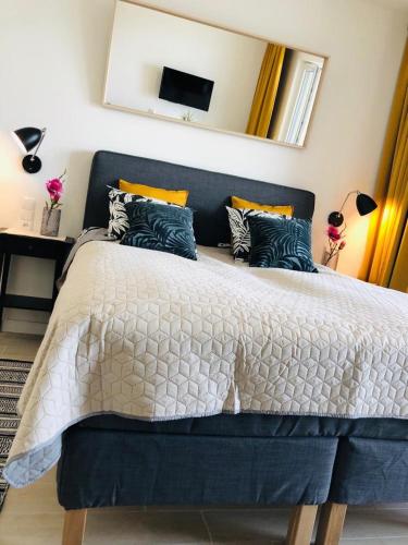 a bedroom with a bed with a blue and white comforter at AQUAMARINA ONYX GOLD in Międzyzdroje