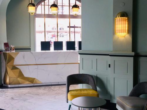 a lobby with two chairs and a table and a counter at Grand Hôtel Bristol in Colmar