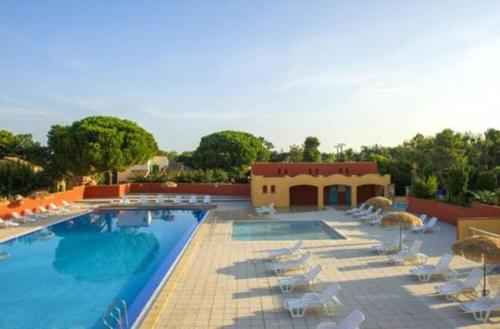 une piscine avec chaises et parasols dans l'établissement Les Albères Asclepieia Appartement Emmanuel, à Argelès-sur-Mer