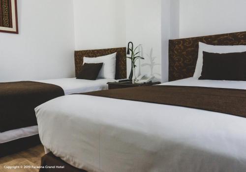 two beds in a hotel room with two beds at Faraona Grand Hotel in Lima