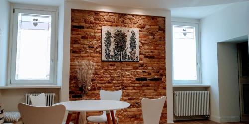 pared de ladrillo en una habitación con mesa y sillas en B&B Dimora Damiani, en Montefiore dellʼAso