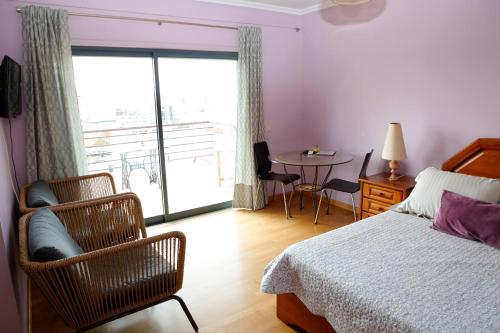 1 dormitorio con cama, mesa y ventana en BellaVita City Faro, en Faro