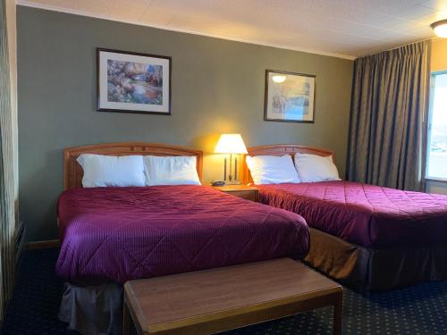 a hotel room with two beds and a window at Scottish Inns Fayetteville in Fayetteville