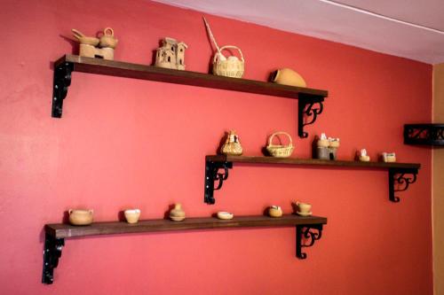 a wall with shelves filled with pottery on it at Hotel Margarita in Puno