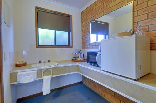 a kitchen with a sink and a refrigerator at Always Welcome Motel in Morwell