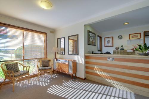 a living room filled with furniture and a large window at Always Welcome Motel in Morwell