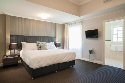 a hotel room with two beds and a television at Oscar's On The Yarra in Warburton