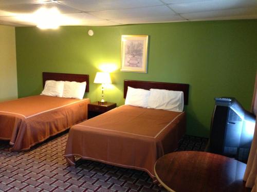 2 łóżka w pokoju hotelowym z zielonymi ścianami w obiekcie Red Carpet Inn Niagara Falls w mieście Niagara Falls