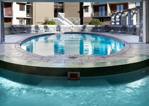 a large pool with blue water in a building at Rendezvous Heritage Hotel Queenstown in Queenstown