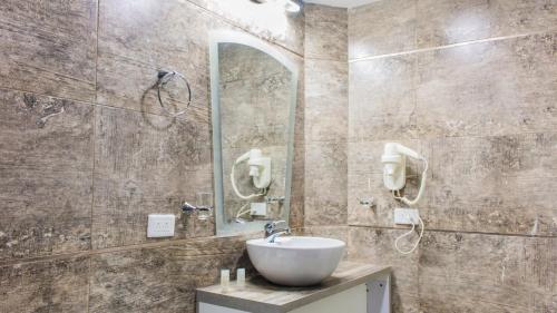 y baño con lavabo y espejo. en Hotel Ciudad Latin Palace, en Guayaquil