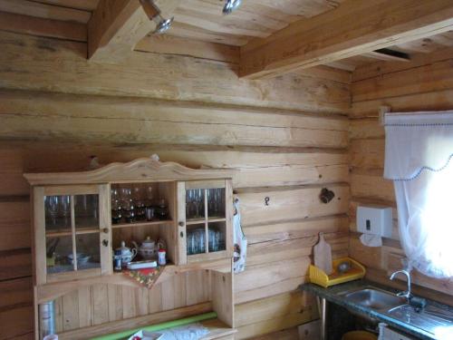 a kitchen in a log cabin with a wooden wall at Laba Oma in Cēsis