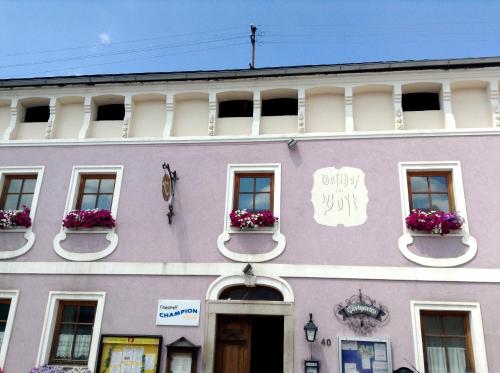 a purple building with windows and flowers on it at Frühstückspension zur Post Reisinger KG St Oswald in Sankt Oswald bei Freistadt