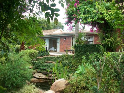 a brick house with a garden in front of it at Aziza Guest House in George