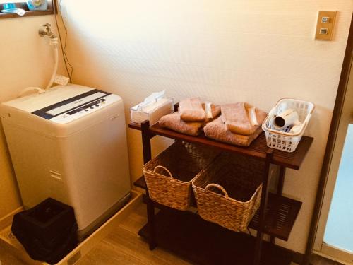 a laundry room with a washer and a table with towels at 島の宿 近 〜KON〜 in Oshima