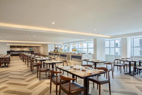 a restaurant with tables and chairs and a bar at Days Hotel & Suites by Wyndham KL - Chan Sow Lin MRT or LRT in Kuala Lumpur