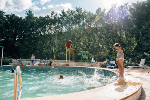 a young child playing in a swimming pool at Del Rio Riverside Resort in Wisemans Ferry