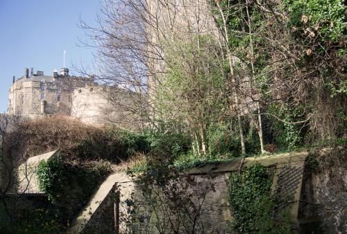 a stone wall with a castle in the background at Grassmarket Old Town Boutique Apartment in Edinburgh
