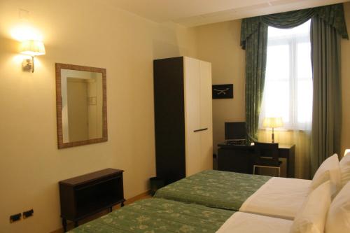 a hotel room with a bed and a mirror at Domus Mariae Benessere in Siracusa