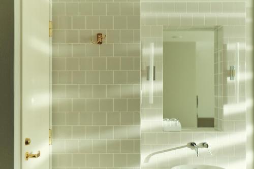 a bathroom with a shower with a sink and a mirror at Hotel It Osaka Shinmachi in Osaka