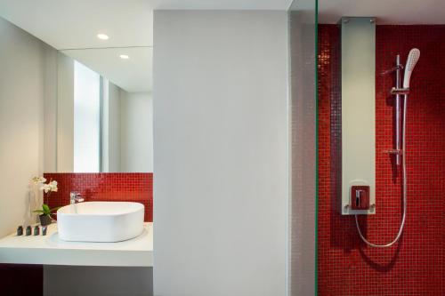 a bathroom with a sink and a shower with red tiles at Days Hotel & Suites by Wyndham Fraser Business Park KL in Kuala Lumpur