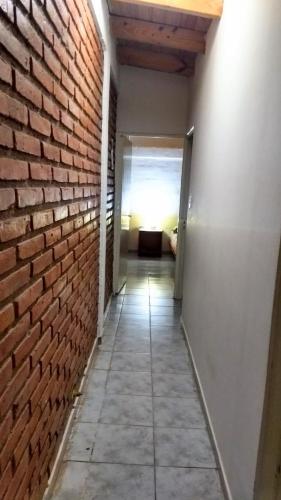 an empty hallway with a brick wall and a room at El Pasaje in Malargüe