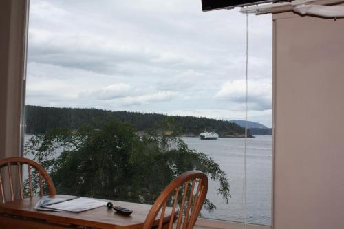 a table with chairs and a view of the water at Sweet Escape & Summer Dream in Friday Harbor