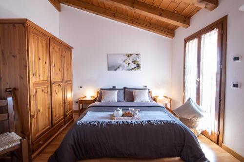 1 dormitorio con cama grande y ventana grande en Al Confine, en Cormòns