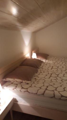 a bedroom with a bed with two lamps on it at Guest House Tena in Slunj
