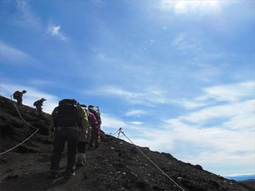 a group of people walking up the side of a mountain at K's House Hokkaido - Asahidake Onsen Hostel in Higashikawa