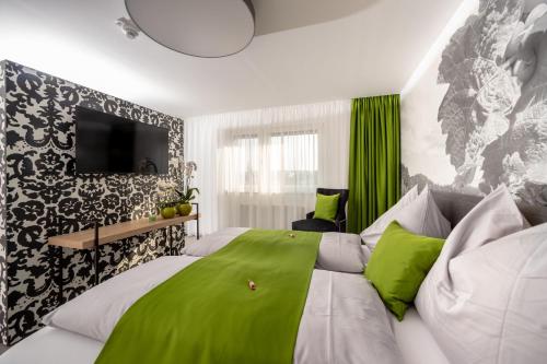 a bedroom with a large bed with green sheets at Hotel Greenrooms in Graz