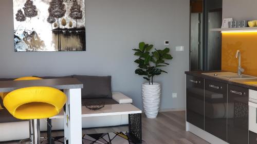 a kitchen with a table and a yellow stool at APARTAMENT ELEGANCE YELLOW in Rewal