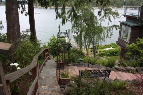 a stairway leading down to a lake with a bench at Sweet Escape & Summer Dream in Friday Harbor
