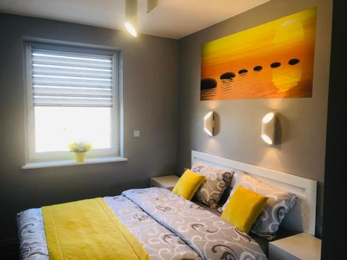 a bedroom with a bed and a window at APARTAMENT ELEGANCE YELLOW in Rewal