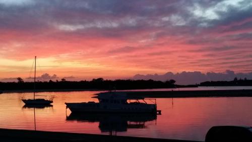 a sunset with two boats in a body of water at Beaconlea in Gold Coast