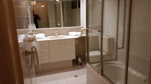 a bathroom with a shower and a sink and a toilet at Beaconlea in Gold Coast