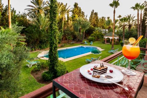 een tafel met een stuk cake en een drankje bij Double room in a charming villa in the heart of Marrakech palm grove in Marrakesh