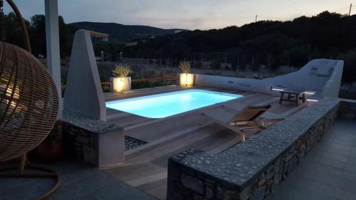 a swimming pool on a deck with a table and chairs at seaside Ktima KaParos PAROS in Drios