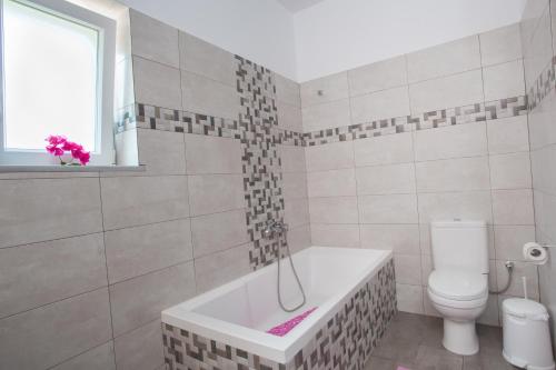 a bathroom with a bath tub and a toilet at seaside Ktima KaParos PAROS in Drios