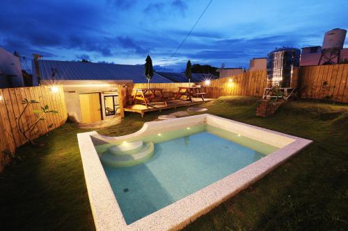 una pequeña piscina en un patio por la noche en Grass Villa, en Eluan