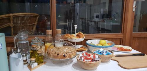 einen Tisch mit Schalen Brot und anderen Lebensmitteln in der Unterkunft Albergue Bergando in Negreira