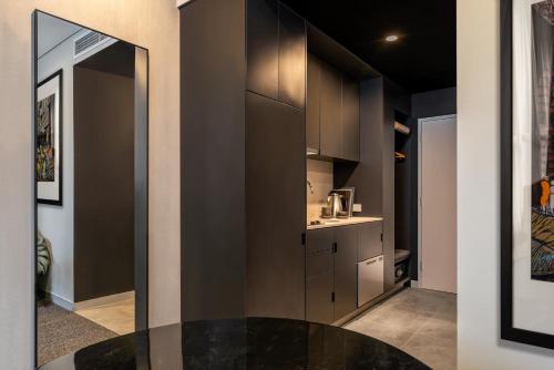 a kitchen with black cabinets and a black table at Veriu Green Square in Sydney