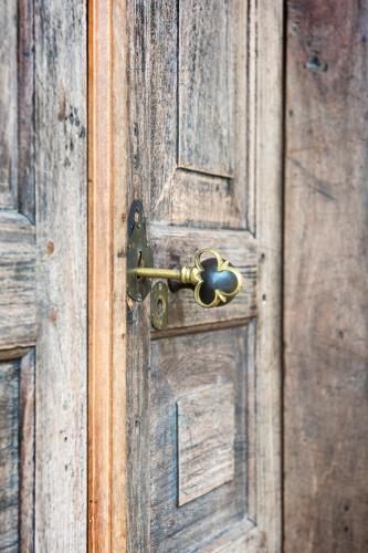 an old wooden door with a brass door knob at The Kandy Samadhicentre in Kandy