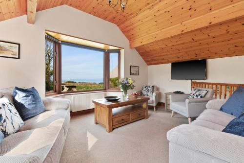 a living room with two couches and a large window at Y Bwthyn in Haverfordwest