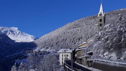 uma igreja no meio de uma montanha de neve em Red House em Valdidentro