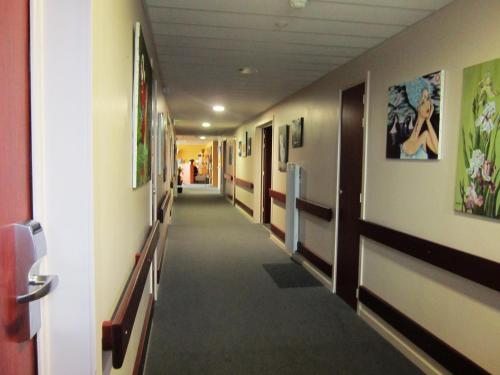 a hallway in a hospital with a long aisle at Hôtel Particulier VILLA DES MARAIS in La Chevrolière